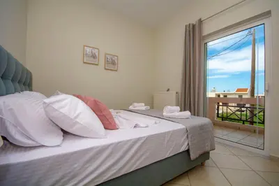 a bedroom with a bed with a view of a balcony at Jasmine House Kissamos in Kissamos