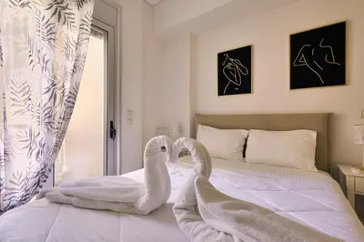 two swans are standing on a bed with towels at Lazaretta apartment 2 in Chania Town
