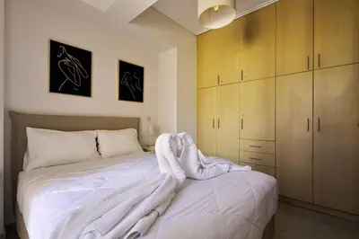 a bedroom with a bed with a white blanket on it at Lazaretta apartment 2 in Chania Town