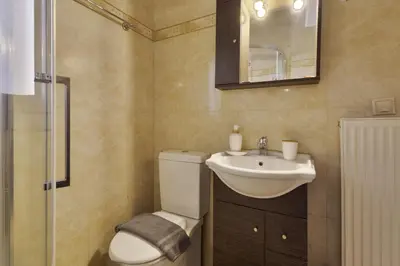 a bathroom with a toilet and a sink and a mirror at Lazaretta apartment 2 in Chania Town