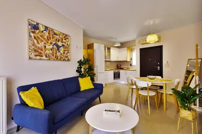 a living room with a blue couch and a table at Lazaretta apartment 2 in Chania Town