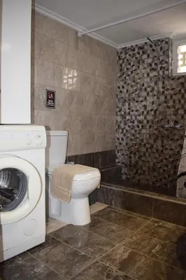 a bathroom with a toilet and a washing machine at Agrabeli Cot Not Just a Stay A Unique Experience in Plátanos