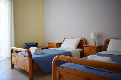 a bedroom with two beds with blue sheets at Agrabeli Cot Not Just a Stay A Unique Experience in Plátanos