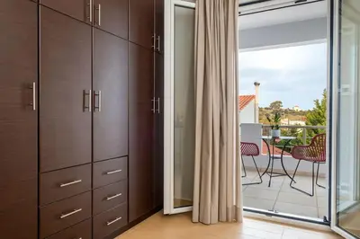 a kitchen with wooden cabinets and a balcony with a table at Emma Hills Villa in Korakiaí