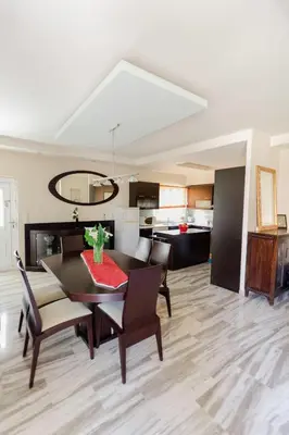 a dining room with a table and chairs and a kitchen at Arias'-Welcoming Guest House in Kounoupidhianá