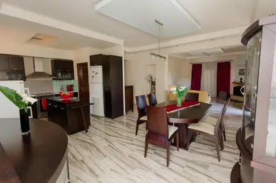 a kitchen and living room with a table and chairs at Arias'-Welcoming Guest House in Kounoupidhianá