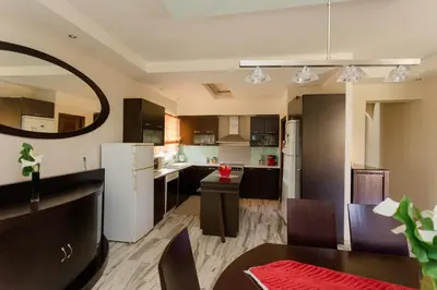 a kitchen with black cabinets and a white refrigerator at Arias'-Welcoming Guest House in Kounoupidhianá