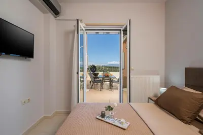 a living room with a couch and a television and a table at Olive Tree Villa in Chania Town
