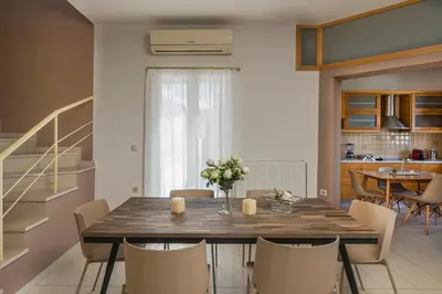 a dining room with a wooden table and chairs at Olive Tree Villa in Chania Town