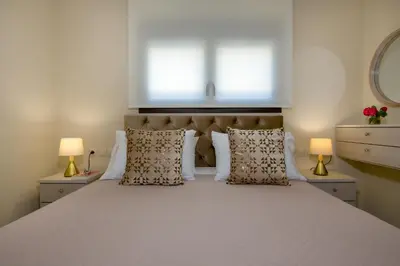 a bedroom with a large white bed with two lamps at Aretousa Home in Chania Town