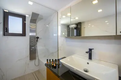 a white bathroom with a sink and a shower at Aretousa Home in Chania Town