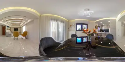 a living room with a dining table and a kitchen at Aretousa Home in Chania Town