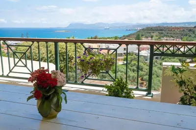a vase of flowers sitting on a table on a balcony at Deja Blue Chania in Daratso