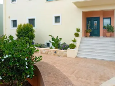 a house with a green door and potted plants at Deja Blue Chania in Daratso