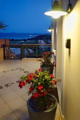 two planters with red flowers on a balcony at night at Deja Blue Chania in Daratso