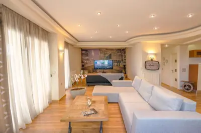 a living room with a white couch and a table at Deja Blue Chania in Daratso