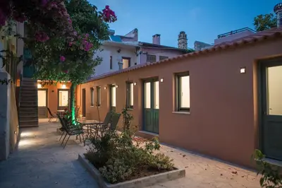 a courtyard of a house with chairs and flowers at Lindas Convent Garden Home 2 in Chania Town