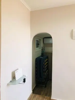 a hallway with an archway and a suitcase in a room at Ariadni's apartment 3 in Chania Town