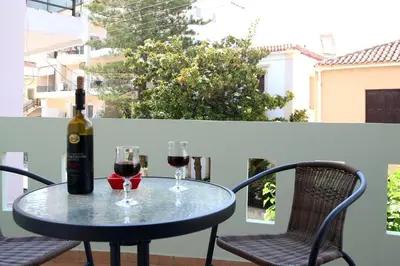 a table with two glasses of wine on a balcony at Anna Kavros appartment in Chania Town