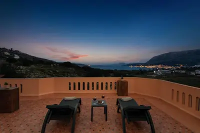 a patio with chairs and a table on a balcony at Villa Androniki in Souda