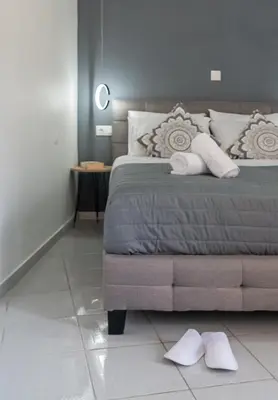 a bedroom with a bed with two white towels on it at Michail Suite Chania δίπλα στην παραλία της πόλης in Chania Town