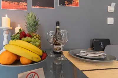 a bowl of fruit on a table with wine glasses at Michail Suite Chania δίπλα στην παραλία της πόλης in Chania Town