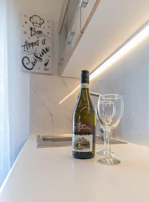 a bottle of wine sitting next to a wine glass at Michail Suite Chania δίπλα στην παραλία της πόλης in Chania Town