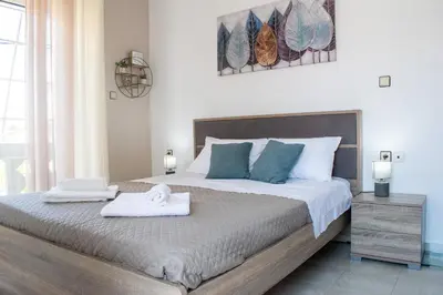 a bedroom with a large bed with two towels on it at Eva's Residence, Family Apartment in Chania Town