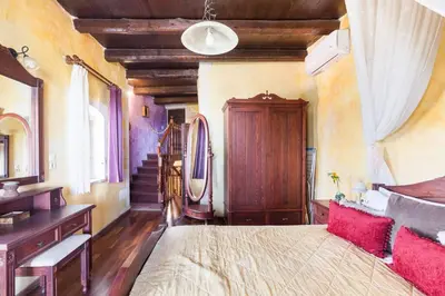 a bedroom with a bed and a desk and a staircase at Samonas - 5 maisonettes with breathtaking views in Chania Town