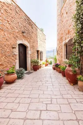 a stone pathway with potted plants on the side of a building at Samonas - 5 maisonettes with breathtaking views in Chania Town