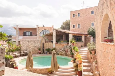 a house with a swimming pool in front of a building at Samonas - 5 maisonettes with breathtaking views in Chania Town