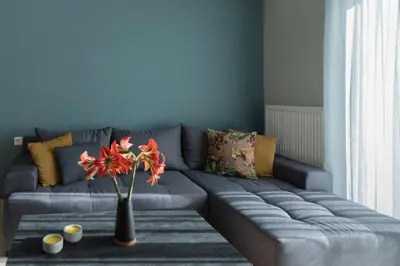 a living room with a gray couch with a vase with flowers at Dejaview cozy apartment by 8essentially in Chania Town