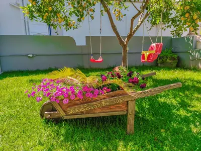 a wooden planter filled with flowers and a tree at Lampros house in the countryside in Chania Town