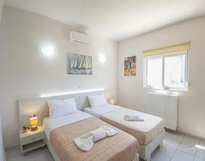 a bedroom with two beds and a window at Lampros house in the countryside in Chania Town