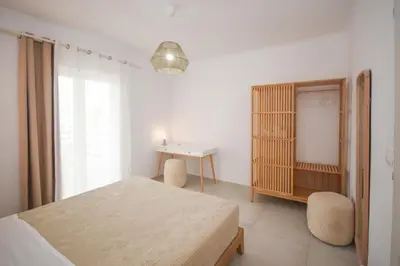 a bedroom with a bed and a table and a desk at Elia Apartments in Falasarna
