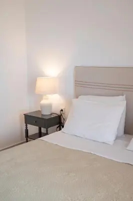 a bedroom with a bed and a table with a lamp at Elia Apartments in Falasarna