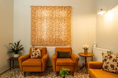 a living room with two chairs and a window at ANMI Hospitality in Chania Town