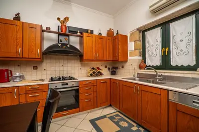 a kitchen with wooden cabinets and a sink at Agnadia Villa in Stalos