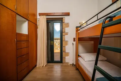 a bedroom with bunk beds and a door to a balcony at Agnadia Villa in Stalos