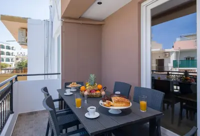 a table with a bowl of fruit on a balcony at G & E Apartment in Kissamos