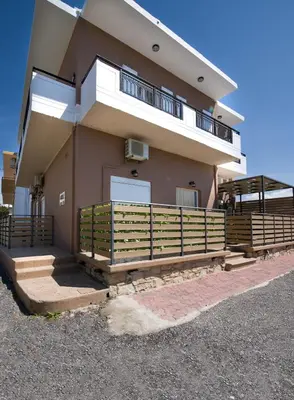 a house with a balcony and a fence in front of it at G & E Apartment in Kissamos