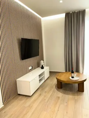 a living room with a table and a flat screen tv at Chania Memories in Chania Town