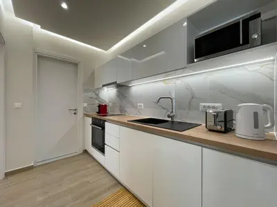 a kitchen with white cabinets and a sink and a microwave at Chania Memories in Chania Town