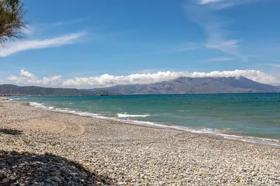 a rocky beach with a mountain in the background at Gold Crest Home in Drapanias beach, Nopigia in Kissamos