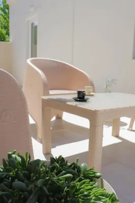 a table and chairs with a cup on top of a plant at Hygge Home Chania in Chania Town