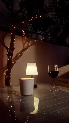 a table with a glass of wine and a lamp at Hygge Home Chania in Chania Town