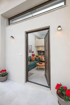 an open door to a living room with red flowers at Ontas apartment in Kissamos in Kissamos