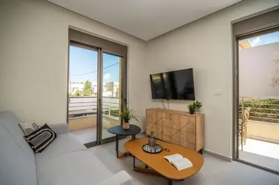 a living room with a couch and a tv and a table at Cozy Spot II near the beach in Ayiá