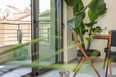 a room with a window and a table and plants at Cozy Spot II near the beach in Ayiá
