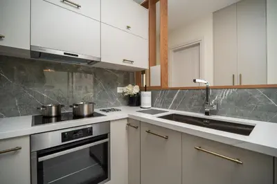 a kitchen with white cabinets and stainless steel appliances at Cozy Spot II near the beach in Ayiá